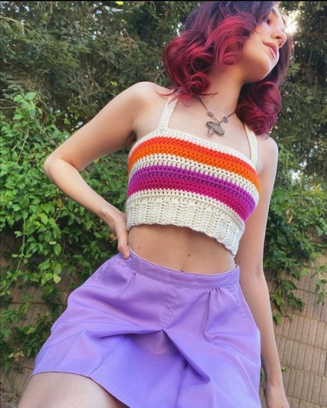 There is a beautiful girl wearing crochet top in colors of lesbian flag Lesbian Crochet Bag, Lesbian Flag Crochet Top, Lesbian Pride Crochet, Lesbian Crafts Diy, Pride Crochet Projects, Lesbian Crochet Patterns, Crochet Pride Outfit, Crochet Pride Top, Lesbian Flag Outfit