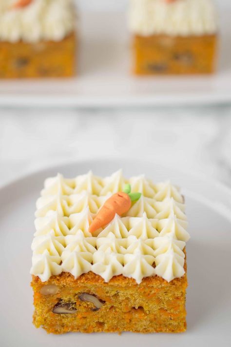 Easy and moist carrot cake made sheet cake style and cut into squares. These carrot cake squares are perfect individual sizes with added walnuts and adorned with decoratively piped cream cheese frosting.