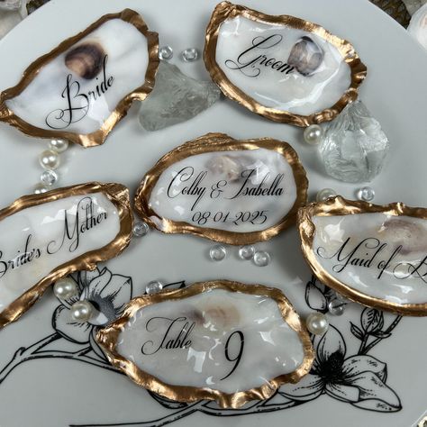 Flat Oyster Table Place Cards, Gold & Natural Place Cards https://www.etsy.com/listing/1748141079 These flat (not cupped) personalized oyster shells are the perfect way to🥂 𝓦𝓸𝔀 your guests at your coastal wedding or event. Your guest will be surprised to know that they have a very special keepsake to take with them. Your tables will be stunning and elegant with the table numbers on these shells that match the guest’s keepsakes. A thoughtful gift that they will always cherish on their very spe... Oyster Table, Natural Place, Table Place Cards, Coastal Wedding, Oyster Shells, Time Design, Table Numbers, Place Cards, Thoughtful Gifts