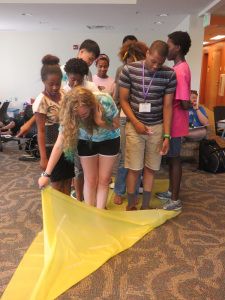 Team Building Activity: Beach Towel Flip | GUIDE, Inc. Kids Team Building Activities, College Track, Steam Lab, Building Games For Kids, Fun Team Building Activities, Team Building Activity, Cousin Camp, Summer Camp Games, Youth Group Activities