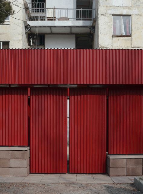 Made of pivoting red corrugated metal panels raised on a base of breeze blocks, the pavilion offers is a sheltered spot for neighbours to gather. Corrugated Metal Door, Nishizawa Architects, Moving Wall, Mac Cosmetic, Bathroom Basins, Moving Walls, Metal Columns, Movable Walls, Metal Facade