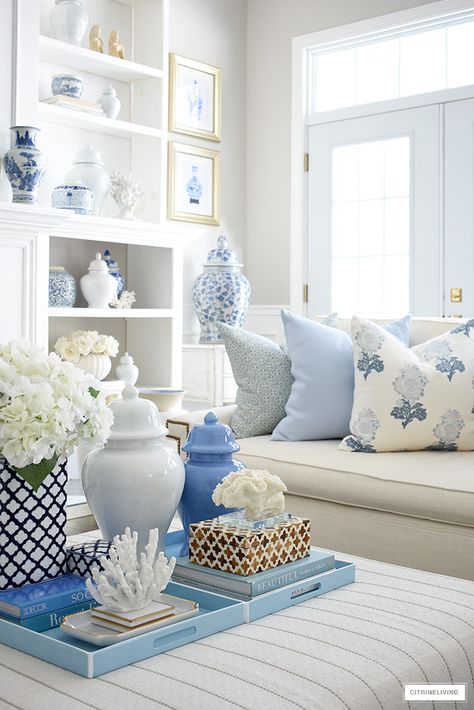 Spring living room decorating - coffee table styled with light blue trays, decorating books, decorative boxes, ginger jars and coral sculptures and faux hydrangeas. Hamptons Style Living Room, Spring Living Room Decor, Blue And White Living Room, Spring Living Room, Blue Living Room Decor, Blue White Decor, Coastal Living Rooms, White Living Room, Blue Living Room