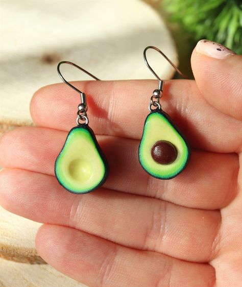 This cute Avocado Earrings will definitely make your days happier! :) If you love to wear food earrings or you are searching avocado gifts for avocado lovers then you came to the best place! This is a mismatched earrings that represents two parts of a ripe avocado - one halve has a seed and the other one is empty. D E T A I L S: * Handmade Avocado Dangle Earrings * Made from Polymer Clay * Length: 1 inches (2.5 cm) * Mismatched: one halve has a seed and the other one is empty * Earring posts: St Cheap Fun Polymer Clay Jewelry, ￼clay Earrings, Cheap Cute Polymer Clay Earrings, Funky Clay Earrings Air Dry, Avocado Crochet Earrings, Polymer Food Earrings, Crazy Earrings Clay, Polymer Clay Earrings Cute Food, Cute Food Earrings