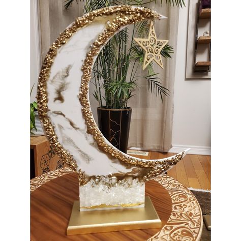 "Ramadan is a time of spiritual reflection, growth, family gatherings, and celebrations. It's also a great time to decorate your home with festive touches that will help you get into the spirit of things. This beautiful moon stand is the perfect way to add some Ramadan vibes to your home. The moon stand is made from resin, with a colorful finish that will brighten up any room. The edges are decorated with broken golden glass, which catches the light and adds extra sparkle. And best of all, it co Ramadan Resin Art, Resin Ramadan, Ramadan Accessories, Shaadi Aesthetic, Islamic Furniture, Eid Cupcakes, Islamic Prayers, Decoraciones Ramadan, Ramadan Vibes