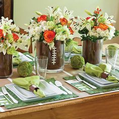 This football party tablescape was created with ease and convenience in mind. It's cleverly built around everyday dishes and glassware and crowd-pleasing decorations. A neutral color palette of brown, green, and white works for any team.   Two different-sized glass cylinders, one inside the other, make up the centerpieces. Scrapbook paper trimmed to size fills the space between the Football Party Table, Football Banquet Centerpieces, Football Centerpieces, Banquet Centerpieces, Football Banquet, Football Wedding, Football Party Decorations, Sports Banquet, Football Baby Shower