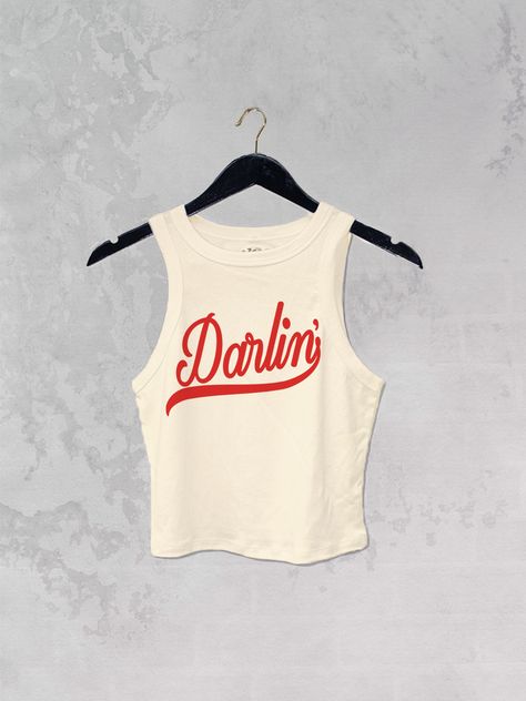 Get all of the southwestern vibes in this Darlin' western inspired retro 90's style cropped tank! - Features the phrase " Darlin' " in a red ink - Screen print transfer that is heat pressed onto each tshirt - Tshirt is a super soft, 90s style micro ribbed baby tee - Regular Baby Tee Fit - Cotton / Poly Blend *due to screens and filters colors may vary slightly to photos* Concrete Cowgirl, Red Tshirt Outfit, Cowgirl Baby, 90s Tshirt, Western Clothes, Bachelorette Ideas, Nashville Style, Nashville Trip, Turtle Tattoo