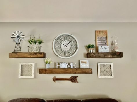 Floating Wall Shelves Above Couch, Over The Coach Wall Decor, Above Tv Shelf Ideas, Three Shelves Above Couch, Shelf Above Wall Mounted Tv, Wall Clock With Shelves, Mirror And Shelf Wall Decor Living Room, Floating Shelves With Clock, Clock And Shelves Wall Decor