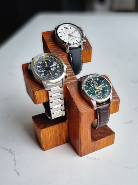 Wooden watch display stand. Elegant way to exhibit your watches. Handmade out of solid wood and stained to create rustic finish. Perfect gift idea for a watch enthusiast who likes to put their prized possessions on show.  Top part is designed to rest the watch case on the angle in a very presentable position. This is also very functional for the solar powered watches that should not be stored away.  Stands are crafted from solid pieces of timber therefore natural imperfections like knots or crac Watch Stand Design, Timber Jewellery Stand, Wooden Watch Holder, Wooden Small Projects, Wooden Watch Stand, Woodwork Gift Ideas, Diy Watch Display, Stand Wood Design, Watch Stand Diy