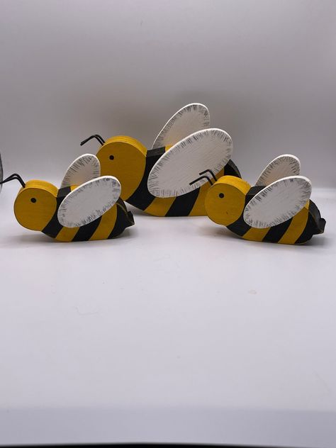 "Add a little spark to your hive with this adorable bee trio! The trio has one larger bee (The Queen) which is 5\" long and 3 1/2 \" tall, and two smaller worker bees which are 3\" long and 2\" tall. These are the perfect size to put a little sting into any bookcase, desk, or shelf. They also fit well into a tiered tray display. Each bee is painted, then sanded and stained to give it a rustic, distressed appearance. Remember, each bee is hand made, so slight variations may occur...giving it that Wooden Bumble Bee Craft, Wood Bumble Bee, Scraps Of Wood Projects, Bee Wood Crafts, Wooden Bees Diy Wood, Wood Cutouts Patterns Templates Free Printable, Bumble Bee Decorations, Wooden Bee, Wood Bees