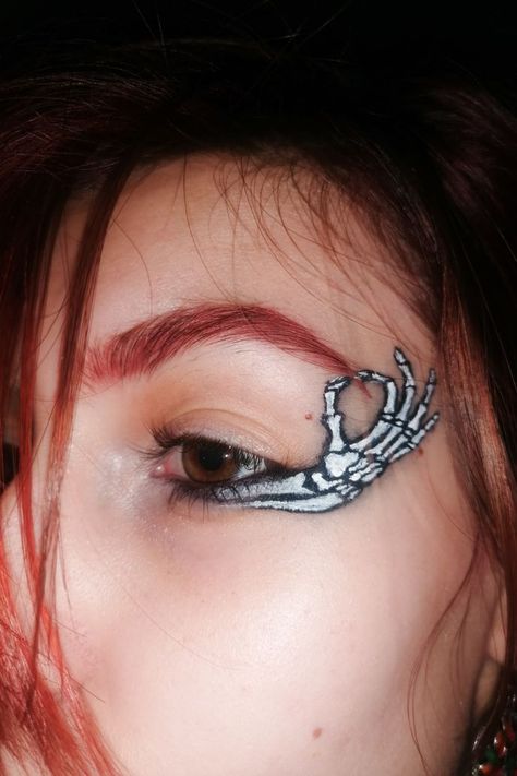 A close up of a girl with red hair and brown eyes. She has a skeleton hand makeup as eyeliner. Skeleton Hand Aesthetic, Skeleton Eyeliner, Makeup Creative Ideas, Red Eyebrow, Bones Aesthetic, Makeup Brown Eyes, Skeleton Aesthetic, Aesthetic Eyeliner, Red Hair Aesthetic