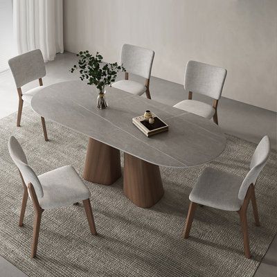 The centerpiece of this set is the oval-shaped gray tabletop, crafted with high-quality sintered stone. Known for its durability and resistance to scratches and heat, the tabletop not only adds a sleek and stylish look but also ensures long-term use without compromising its beauty. The table legs, a striking contrast to the gray tabletop, are made from sturdy and sustainable ash solid wood. The rich brown color of the legs adds warmth and enhances the contemporary appeal of the set. The combinat Dinning Tabletop, Dinning Room Design, Counter Height Dining Sets, Oval Table, Oval Table Dining, Grey Kitchen, Pedestal Dining Table, Pedestal Table, Solid Wood Dining Table