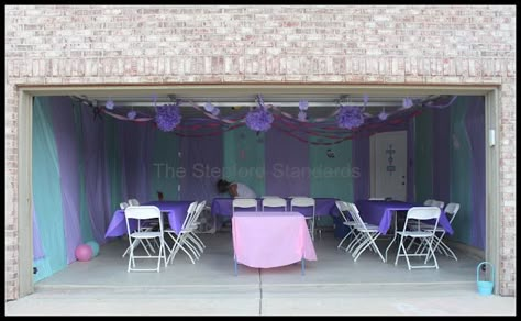 We did not want our guest to have to stare at our tools/lawn equipment so we ended up wrapping the entire garage with rolls of plastic table clothes. A staple gun was used to secure the plastic to the ceiling and again at the bottom of the wall. Then we finished off the look with streamers and tissue paper puffs.  The total cost for this project was less than $20.  The end result turned out looking like a fun circus tent! Far better than we had imagined. Streamer Party Decorations, Trendy Party Decor, Garage Party, Super Party, Party Table Cloth, Plastic Table, Plastic Tablecloth, Plastic Tables, Dinosaur Party