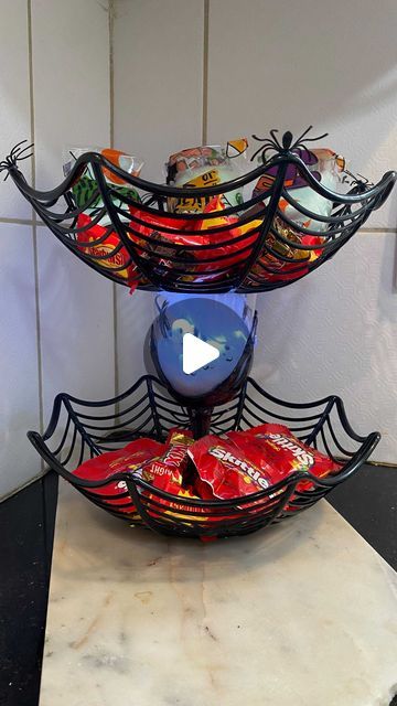 Sarah | Dollar Tree Finds & Life on a Budget on Instagram: "Look how cute this Dollar Tree DIY 2-tiered spider web basket turned out! Everything used is from Dollar Tree (of course 😂) and cost about $5, compare that to the original price of $30 and I’d say it’s easier to diy rather then buy... but what do you think? Buy or DIY?!? @dollartree   You can use this basket to hold candy, snacks or even fruit! It’s perfect for a Halloween Party but I plan to use it as our candy bowl for trick or treaters 👻  If you like this diy be sure to drop a like! It helps me reach more people and means the world to me♥️ If you like this type of content, be sure to follow me and tag a friend so they hangout too!   Did you peep the emoji that’s hidden in This video? If you saw it drop it in the comments belo Dollar Tree Halloween Basket Ideas, Dollar Tree Halloween Candy Bowl Diy, Halloween Candy Bowls Diy, Diy Dollar Tree Halloween Candy Dish, Dollar Tree Spider Bowl, Diy Halloween Candy Bowl, Spooky Baskets For Kids, Candy Dish Diy, Diy Fruit Bowl