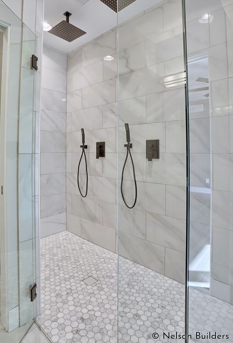 The master shower features two shower heads and a curbless design, for a clean, modern aesthetic. Two Shower Heads On Same Wall, Tile Shower Double Head, Shower 2 Heads, Master Bath Dual Shower Heads, Bathroom Shower Double Head, Shower Remodel Two Shower Heads, Dual Rain Shower Master Bath, Two Showers In One Bathroom, Double Rainfall Shower Ideas