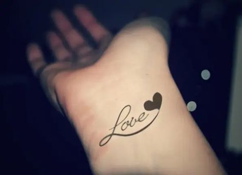 20 Eye-Catching Wrist Tattoo Designs To Make You More Fashionable Love Name Tattoo, My Name Tattoo, Tato Nama, Name Tattoo On Hand, Heart Tattoos With Names, Love Heart Tattoo, Small Wave Tattoo, Love Name, Cool Wrist Tattoos