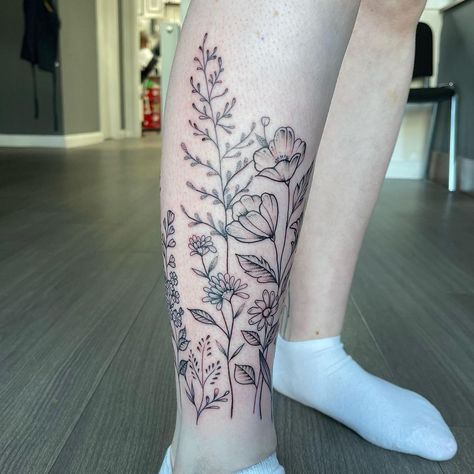 #flowers #legwraptattoo #fineline #wildflowertattoo #calvetattoo #longstems #hand-drawn #femininetattoo #beautifultattoo Floral Tattoo Design Calf, Botanical Leg Wrap Tattoo, Flowers On Calf Tattoo, Birth Flower Tattoos On Leg, Flower Wrap Ankle Tattoo, Flower Garden Leg Tattoo, Calf Wrap Tattoo, Flower Around Ankle Tattoo, Flowers Calf Tattoo