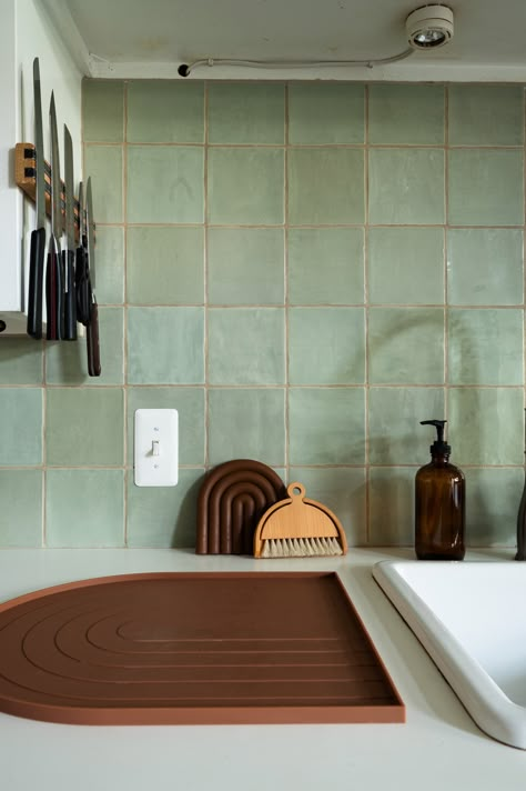 Kitchen with green square tile and white countertops Green Square Backsplash, Green Tile Wood Kitchen, Green Tile White Cabinets, White And Green Tiles Kitchen, Tile Over Countertops, Pale Green Kitchen Backsplash, Pale Green Backsplash, Green Tile White Kitchen, Green Square Tiles Kitchen