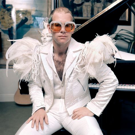 English pop singer Elton John in a flamboyant stage outfit of white suit with feather trim and rhinestone encrusted glasses, circa 1973. Elton John Young, Moda Disco, Elton John Costume, The Human Centipede, Terry O Neill, Portrait Dress, Animal Costumes, Classic Songs, Mötley Crüe