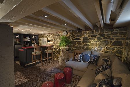 Exposed stone in the basement bar/lounge area is sealed to create a cozy space for unwinding after a night on the town. Exposed Stone Basement, Fieldstone Basement Remodel, Swanky Basement Lounge, Stone Basement Ideas, Stone Basement Remodel, Fieldstone Basement, Basement Bar Lounge, Amazing Basements, Home Bar Lounge