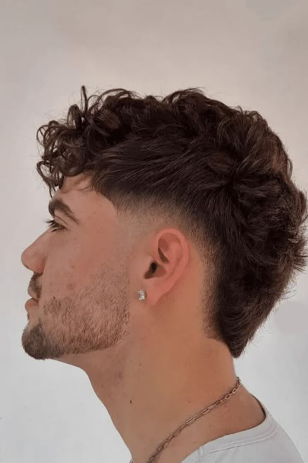 This wavy haircut radiates a relaxed yet fashionable aura with its tousled, textured waves that lend an effortless cool vibe. It incorporates a faded undercut that highlights the volume and movement of the wavy top, creating a distinct contrast that's very much in style. The natural curls take center stage, making this - Click to see more of 36 Captivating Men's Wavy Hairstyles That Will Steal Your Breath Away and follow us for more hairstyle ideas. // Photo Credit: Instagram @cortesparahomens Long Hair Fade, Trending Hairstyles For Men, Mohawk Hairstyles Men, Mens Haircuts Short Hair, Best Haircuts For Men, Burst Fade, Low Fade Haircut, Men's Cuts, Haircuts Short Hair