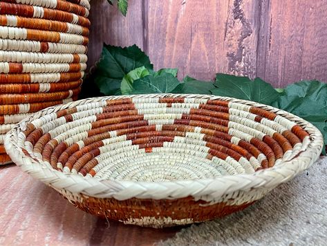 This is a southwest style hand woven basket in the shape of a saucer, perfect for potted plants. The technique of basket making using the coil method is generations old. Handed down from each passing generation the art is preserved. The Hopi pueblo Indians were famous for baskets woven in this fashion that were so tight that they could hold water. Native baskets are popular for southwestern decorating as well as western decor. These traditional baskets are made by hand, artfully woven to form unique patterns. Handwoven baskets are great for cabin, lodge or log home or for your special rustic or Native American room. These also make a great new home gift or housewarming gift! Measures approximately 10.25" diameter and 2.75" tall. Important Shipping Information Free shipping is offered to th American Room, Pueblo Indians, Southwestern Home Decor, Traditional Baskets, Southwestern Home, Southwestern Decorating, Hand Woven Baskets, Southwest Style, Western Decor