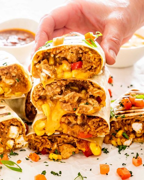 These 30 minute Chicken Burritos are stuffed with a perfectly seasoned chicken filling, Mexican rice, refried beans, corn and lots of cheese. #chickenburritos #recipe Chicken Rice Burrito Recipes, Rice Burrito Recipe, Chicken Rice Burrito, Mexican Chicken Rice, Chicken Burrito Recipe, Rice Burrito, Burrito Recipe Chicken, Mexican Chicken And Rice, Tex Mex Chicken