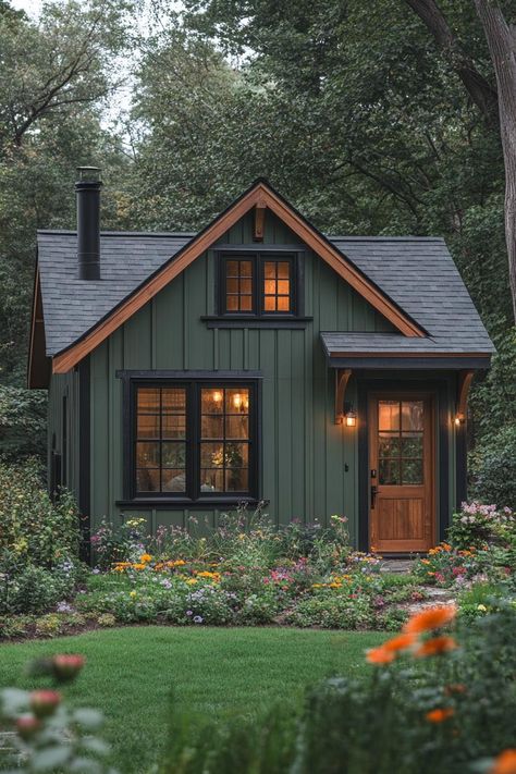 Cozy cabin surrounded by lush greenery and vibrant flowers. Little cabins with less space can equal more joy, laughter, and maybe even a whole new perspective on what “downsizing” truly means. Green Cabins, Green Cabin, Lakehouse Ideas, Cabin Modern, Wood Facade, Wooden Facade, Cottage Cabin, Farmhouse Garden, Little Cabin