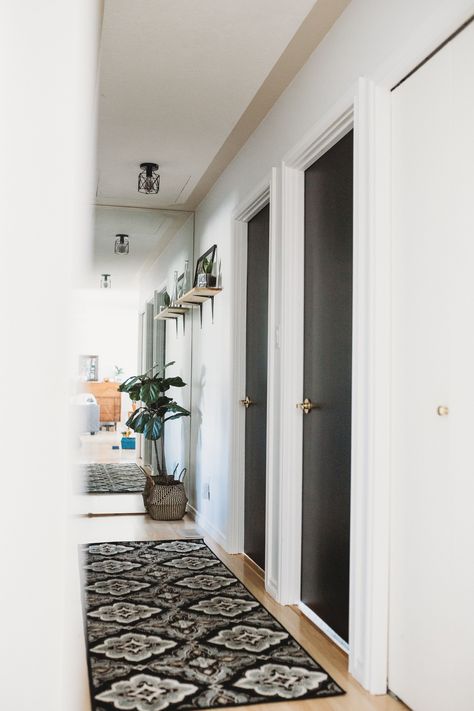 Black doors contrast white hallway Hallway Decorating Black Doors, Black Interior Hall Doors, Black Door Hallway Decor, Black Doors And White Walls, White Hall Black Doors, Hall With Black Doors, Black Indoor Doors Bedroom, Dark Hallway Doors, Black Hall Doors