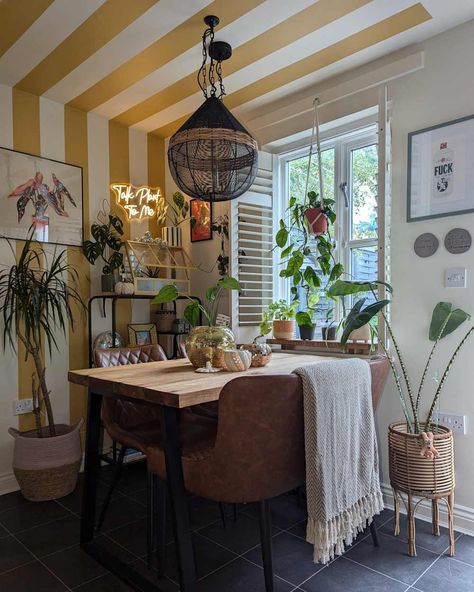 Dining room with yellow and white striped walls, brown leather bench seats, wooden table, and lots of plants Painted Dining Room, Painted Stripes, Apartment Dining Room, Bench Seats, Striped Walls, Rental Apartment, Parisian Cafe, Dining Room Makeover, Dream Furniture