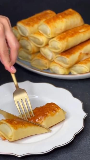 To create deep-fried pancake rolls, a thin pancake batter is prepared by combining flour, water, and sometimes eggs or other flavorings. The batter is then spread thinly on a flat surface, such as a hot griddle or skillet, and cooked until it forms a thin and flexible pancake. The pancake is then filled with a variety of ingredients, such as savory meats, vegetables, and sauces. Once the filling is placed on the pancake, it is carefully rolled up, creating a cylinder shape. Doughnut Recipe Easy, Homemade Donuts Recipe, Recipes For Busy Moms, Cake Recipes Easy Homemade, Savory Pancakes, Cooking Recipes Healthy, Sweet Dishes Recipes, Tasty Recipes Videos, Quick Recipes Snacks