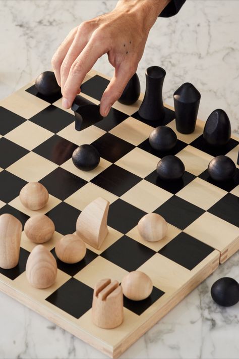 Foldable wooden chess set designed by Panisa Khunprasert. This chess set features minimalist turned-wood chess pieces that evoke modern sculptures. Subtle details are employed to identify the various pieces: a diagonal slice on the oval-shaped Bishop suggests a liturgical headpiece; two deep grooves create castle turrets for the cylindrical Rook; the Knight’s arched lines follow the shape of a horse’s head. Flat Chess Pieces, Clay Chess, Chess Design, Knight Chess, Moma Design, Wood Chess, Chess Sets, The Knight, Ceramic Ideas