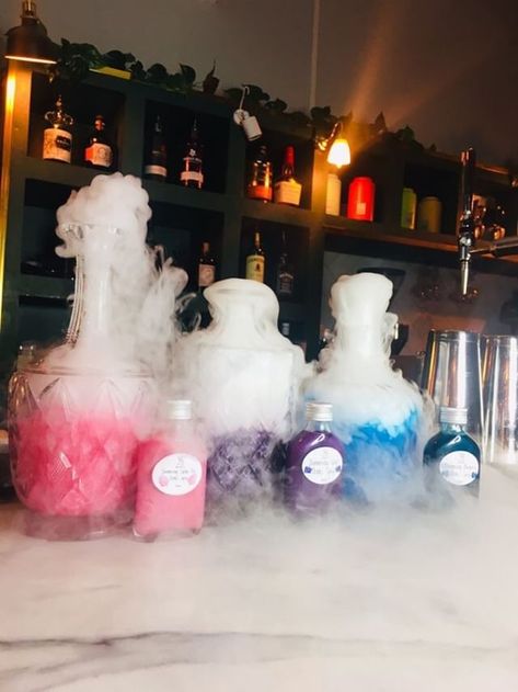 Thank you @unicornshimmerco for the sparkly images and @frankies_crosby for the beautiful bar setting! #cocktails #dryice #dryicecocktails #smokingcocktails #tabledecoration #centerpiece #kidspartyideas #kidsparties #harrypotterparty #magicparty #scienceparty #scienceparties #britishscienceweek #babyshower #birthdayparties Dry Ice Bar Decor, Dry Ice Drink Display, Dry Ice Table Decor, Dry Ice Centerpieces, Science Cocktails, Dry Ice Cocktails, Dry Ice Drinks, Ice Table, Science Display