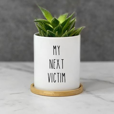 Witty and hilarious "My Next Victim" plant pot for plant lovers! This unique planter adds a fun decorative touch to any home, garden, or workspace. Perfect as a funny birthday or Christmas gift, it's an ideal gardening gift for family and friends. Celebrate special occasions and show you care with this charming succulent pot! DETAILS ▸ Pot has a drain hole and comes with a bamboo saucer ▸ Graphic printed on your pot will never fade or peel ▸ Ideal for succulents, cacti, air plants, or starter pl Plant Cricut Ideas, Plant Puns Funny, Cricut Gift Ideas For Women, Planter Sayings, Funny Planters, Funny Plant Pots, Unique Planter Ideas, Funny Plant Sayings, Garden Humor