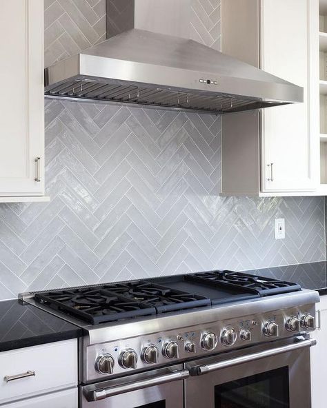 Gray glazed herringbone tile backsplash brings style, class, and dimension in a transitional kitchen with white cabinetry and black quartz cabinets. Light Grey Herringbone Backsplash, Grey Herringbone Backsplash, Herringbone Tile Kitchen, Backsplash Herringbone, Herringbone Tiles, Luxury Kitchen Island, Herringbone Tile Backsplash, Backsplash Tile Design, Herringbone Backsplash