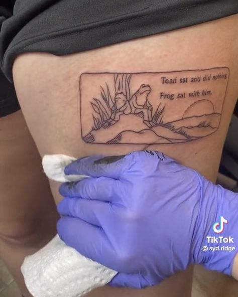 frog and toad tattoo in a rectangle on the thigh. text saying “toad sat and did nothing. frog sat with him.” Frog And Toad Book Tattoo, Frog Toad Tattoo, Frog Tattoo Funny, Frog And Toad Tattoos, Toad Sat And Did Nothing, Frog And Toad Quotes, Frog And Toad Art, Frog And Toad Tattoo, Rectangle Tattoo