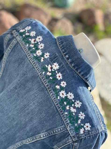 This is a custom embroidered denim jacket. I do this all by hand. There is also an element of heat transfer vinyl so that it makes the embroidery pop a bit. I am happy to make any design you like. Please message me for custom orders. I've washed this kind of jacket many times so it seems that the embroidery holds up very well.  The front of the Jacket does not have any embellishment on it.  If you would like something extra, please include a message so we can collaborate.  The jacket will make a Denim Jacket Embroidery Ideas Simple, Embroidery On Jacket, Denim Embroidery Jacket, How To Style A Denim Jacket, Jean Jacket Embroidery Ideas, Embroidery On Denim Jackets, Jean Jacket Embroidery, Hand Embroidered Denim, Denim Jacket Embroidery