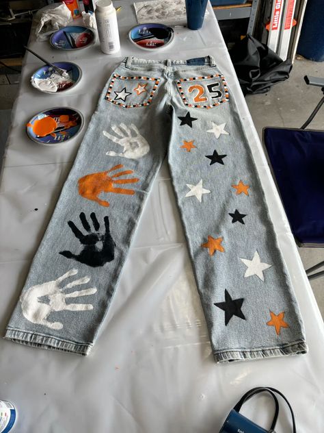 senior jeans inspo Senior Year Pants, Homecoming Jeans Painted, Pant Painting Ideas, Senior Jeans Painted 2025, Painted Jeans School Spirit, Senior Homecoming Jeans, Hoco Jeans Painted, Senior Year Jeans, Senior Jeans Ideas High Schools