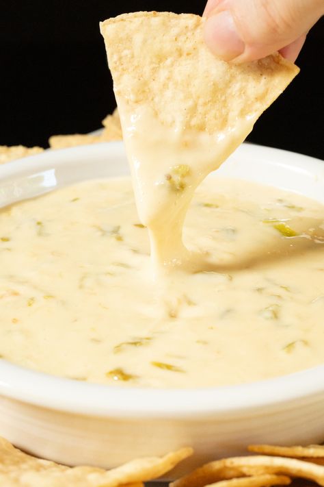 A hand holds up a tortilla chip that has been dipped in hatch chile queso. A bowl with the rest of the dip is out of focus in the background. Hatch Chili Queso Dip, Hatch Queso, Green Chile Queso, Queso Recipes, White American Cheese, Dairy Free Dips, Hatch Chiles, Cheesy Appetizer, Queso Dip Recipes