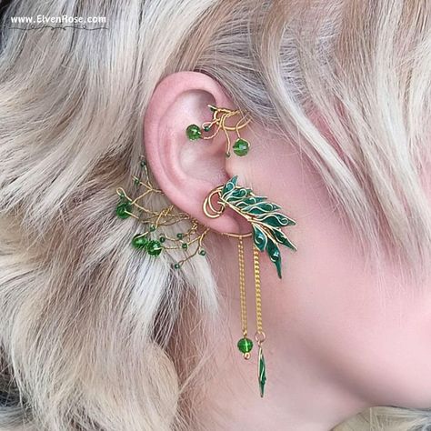 Embrace the enchanting allure of the forest with our "Verdant Aurëlinn" Elven Ear Wrap Earring, part of the Elvenwood Blossoms Collection. Crafted with meticulous attention to detail, this exquisite earpiece captures the essence of Elvish elegance. Handcrafted from non-tarnish gold-plated wire, each intricate twist and curve of the design reflects the graceful beauty of nature. Adorned with shimmering Swarovski crystals and delicately cast resin leaves, this ear wrap gleams with a mesmerizing ch Elvish Jewelry, Ear Wrap Earrings, Gold Leaf Design, Elf Ear Cuff, Fantasy Earrings, Fairy Ears, Anime Earrings, Elven Jewelry, Wrap Earrings