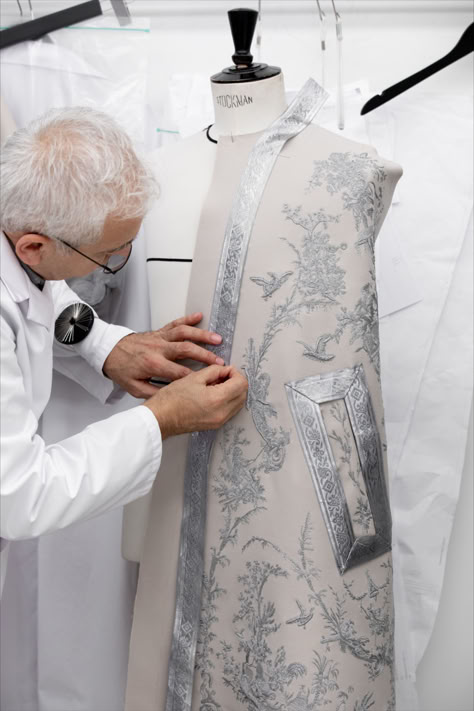 In the House's ateliers, witness several steps in the creation of an exceptional couture cape for Dior Men Winter 2024-2025 by Kim Jones. Once the placements were finalized, the piece was hand-embroidered with toile de Jouy motifs in silver thread and cannetille before being edged with woven passementerie bands and waves of braid, a savoir-faire undertaking totaling some 2000 hours. © Sophie Carre Dior Ribbon, Dior Toile, Fashion Portfolio Layout, Co Ords Outfits, Beauty Dior, Embroidered Cape, Dior Men, Christian Dior Fashion, Christian Dior Couture