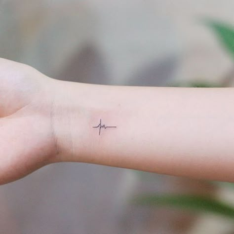 e0a050c5f6b28c9a7a79daf79cc87d81 Minimalist heartbeat wrist tattoo on a person's forearm, symbolizing life and vitality, against a blurred background. | Sky Rye Design Ecg Tattoo, Heart Rate Tattoo, Lifeline Tattoos, Line Tattoo Arm, Ekg Tattoo, Doctor Tattoo, Nurse Tattoo, Heartbeat Tattoo, Medical Tattoo