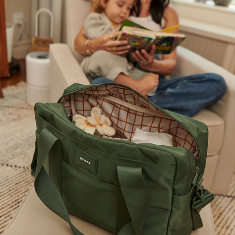 This product is fulfilled by our friends at State Bags and will be shipped separately. M+A Approved  Designed for parents, by parents and packed with features to keep you organized on the go- including an insulated interior bottle pocket, a changing pad, a slip pocket for your phone, and hooks that easily attach to your stroller, plus a travel sleeve for easy travel.  Inside, you'll find a separate padded compartment that fits up to a 14" laptop and a back pocket that can accommodate up to a 13" iPad. The main compartment offers two large mesh pockets with elastic—perfect for holding diapers and wipes—and additional interior pouches for other essentials like pacifiers, bibs, and toys. A separate pouch is provided for dirty clothes, keeping everything else clean and organized. This tote ens Diaper Bag Aesthetic, Baby Bags For Mom, Bags Organization, Cute Diaper Bags, Organization Travel, Baby Hospital Bag, Stylish Diaper Bag, Barbie Kids, Best Diaper Bag