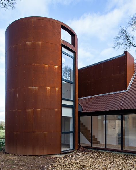 A circular tower echoes the former gas storage cylinder that once occupied its place. It houses a private study. Exterior Metal Siding, Brutalist Buildings, Metal Siding, Architecture Design Drawing, Tower House, Mid Century Architecture, Modern Beach House, Modern Barn, Brick Building