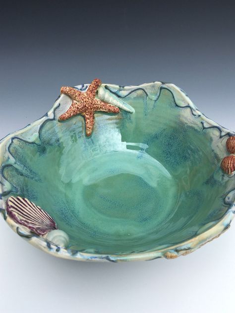 This beautiful opalesent seafoam blue green beach themed one of a kind seashell pottery bowl is the perfect piece to liven up your beach house or bring the shore home. Although it would be the perfect addition to any beach décor is also very utilitarian. This bowl would be ideal as a centerpiece fruit bowl or showcasing a candle on a coffee table. The bottom of the bowl has a trimmed foot and artist's signature. During a ten step process to make this item the porcelain bowl is first wheel Seashell Pottery, Artistic Pottery, Breaking Waves, Ceramic Serving Bowl, Green Beach, Keramik Design, Slab Pottery, Ceramics Pottery Art, Ceramics Projects