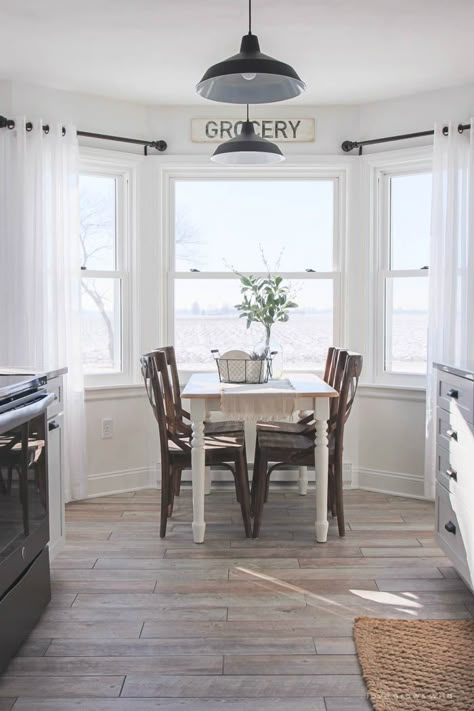 Kitchen Makeover - Flooring | Follow along the makeover of this beautiful farmhouse kitchen! In this post, Liz shares her tile choice for flooring. Bay Window Ideas Kitchen Dining Tables, Farmhouse Kitchen Curtains, Kitchen Bay Window, Trendy Farmhouse Kitchen, Kitchen Window Curtains, Kitchen Table Makeover, Farmhouse Kitchen Tables, Farmhouse Paint, Farmhouse Windows