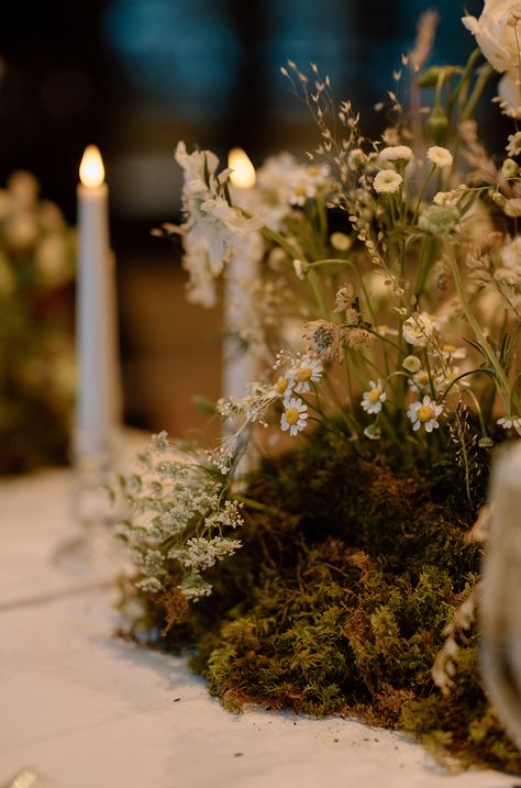 A wedding table centerpiece: the meadow runner - our favorite - with delicate flowers and a mossy base this evokes the feel of flowers growing from the center of the table at this wintry wedding in Vail, Colorado at the Nordic Center Mossy Table Decor, Moss And Pumpkin Centerpiece, Moss Greenery Wedding, Moss Themed Wedding, Moss Table Wedding, Mossy Tablescape, Moss Wedding Centerpiece, Moss Centerpieces Diy, Forest Wedding Table Decor