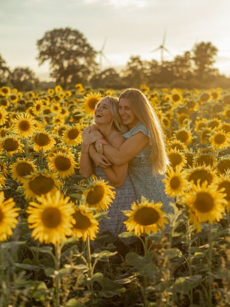 A girl hugging another girl from behind in a sunflower field, both laughing. Fall Sunflower Pictures, Sunflower Field Photoshoot Sisters, Wildflower Picture Poses, Sister Sunflower Photoshoot, Best Friend Sunflower Photoshoot, Sunflower Field Photoshoot Friends, Sunflower Field Picture Ideas, Sunflower Field Photoshoot Poses, Sunflower Pictures Photography Family