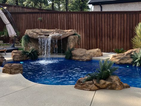 This absolutely stunning rock waterfall grotto is perfect for pools of all sizes. Universal Rocks makes it easy to transform your pool into a one-of-a-kind grotto. Inground Pool With Hot Tub Rock Waterfall, Faux Infinity Edge Pool, Screen Pool Patio Ideas, Waterfall Grotto, Patio Pools, Fiberglass Pool Cost, Spool Pool, Pool Waterfalls, Small Pools Backyard