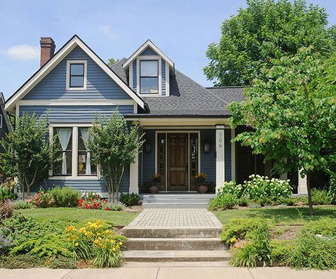 Blue is a universally beloved color that always delights. The calming and notable hue works especially well on homes situated in established neighborhoods or set on tree-lined streets. On this true-blue exterior, white-painted trim outlines roof peaks and windows; black paint highlights window sashes and dentil moldings running across window and door trim. White columns frame the front steps to direct traffic to the entry door. Exterior Color Combinations, Best Exterior Paint, Green Shutters, Brown Roof, Pintura Exterior, Exterior Color Schemes, Exterior Paint Colors For House, Casa Exterior, Country Blue