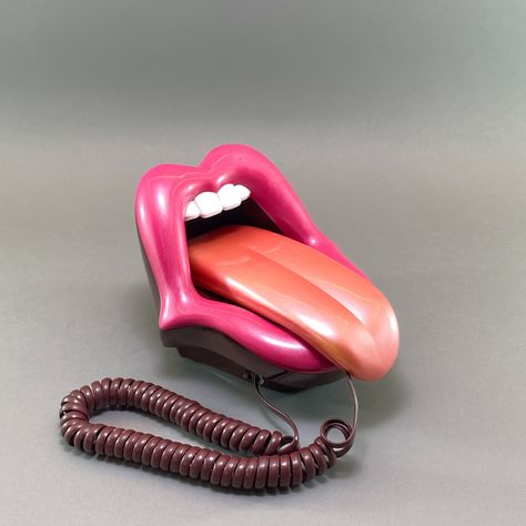 Add a quirky touch to your space with this unique 1990s Pop Art Mouth Telephone! 👄📞 This whimsical landline phone, designed to resemble a mouth with a tongue as the handset, is sure to be a conversation starter. Perfect for collectors and fans of quirky decor, this rare find is fully functional and in mint condition. Imagine the fun and flair it will bring to your home or office! Key Features: 📞 Novelty Landline Telephone - Eye-catching mouth and tongue design. 🏠 Retro Home Decor - Adds a playful and artistic element to any space. 🌟 Collectible - Highly collectible, especially for those who love unique and retro items. ✨ Mint Condition - Pristine condition, fully functional. 🎁 Unique Gift - Ideal for those who appreciate rare and quirky items. 🌍 International Free Express Shipping - Quirky Vintage Home Decor, Weird Accessories Unique, Pop Art Mouth, Pop Art Office, Nostalgic Decor, Art Mouth, Telephone Retro, Novelty Decor, Telephone Vintage